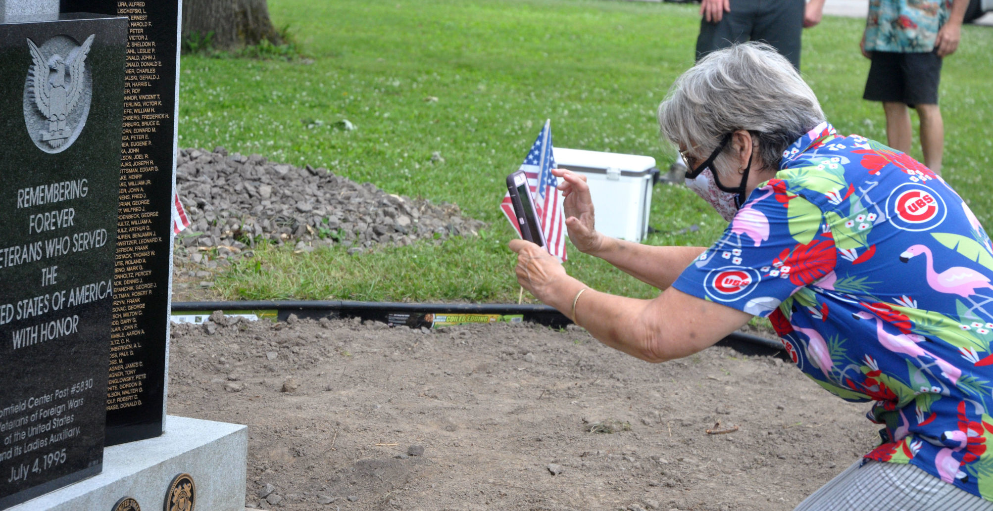 Myra Gallagher takes a photograph of a veterans memorial in the village of Bloomfield
